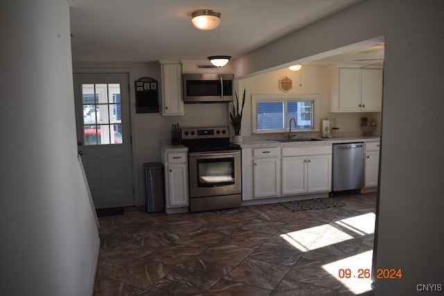 kitchen featuring sink, stainless steel appliances, and white cabinets