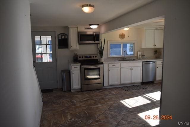 604 Oneida Lake Ave, Sullivan, NY 13032 - kitchen with stainless steel appliances, a sink, white cabinets, and light countertops