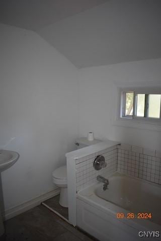 604 Oneida Lake Ave, Sullivan, NY 13032 - bathroom featuring toilet, a garden tub, lofted ceiling, and baseboards