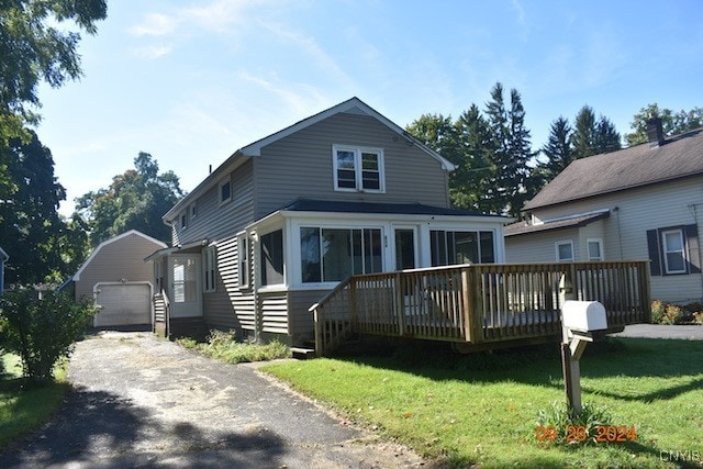 view of front facade with a garage, a front lawn, a sunroom, and a wooden deck