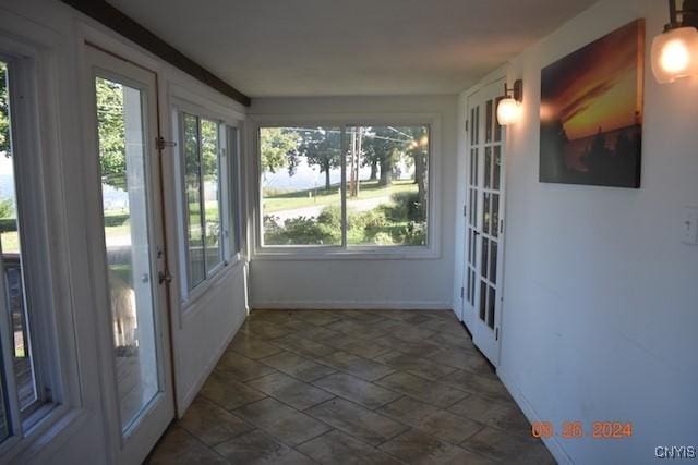 604 Oneida Lake Ave, Sullivan, NY 13032 - unfurnished sunroom featuring french doors, stone finish floors, and baseboards