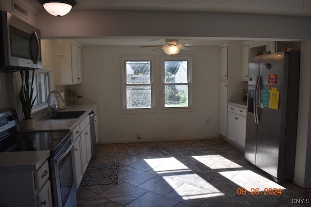 kitchen with ceiling fan, white cabinets, appliances with stainless steel finishes, and sink