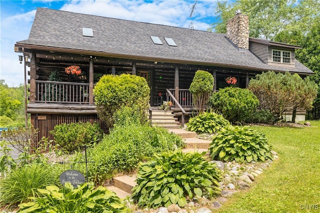 cabin with covered porch and a front yard