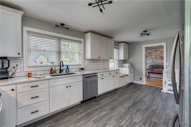 kitchen with white cabinets, appliances with stainless steel finishes, dark hardwood / wood-style floors, and sink