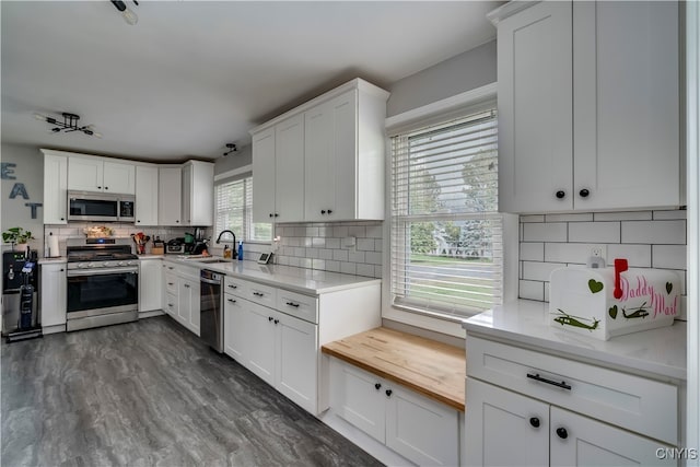 kitchen featuring decorative backsplash, sink, stainless steel appliances, and white cabinets