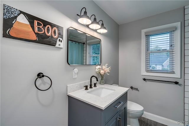 bathroom with a shower with shower curtain, vanity, and toilet