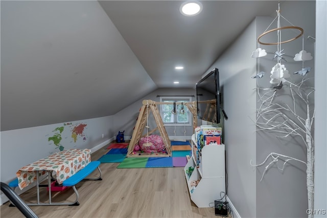 recreation room featuring vaulted ceiling and hardwood / wood-style floors