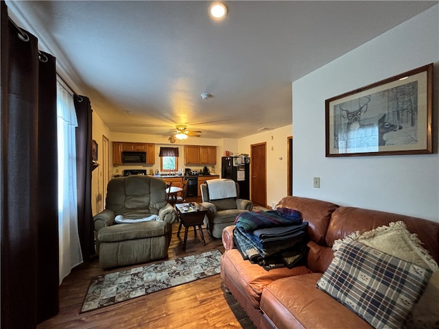 living room featuring light hardwood / wood-style flooring and ceiling fan