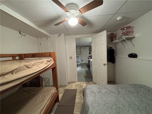 bedroom with a paneled ceiling, ceiling fan, and a closet