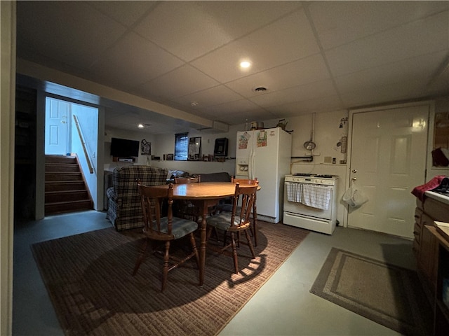 dining room featuring concrete flooring and a paneled ceiling