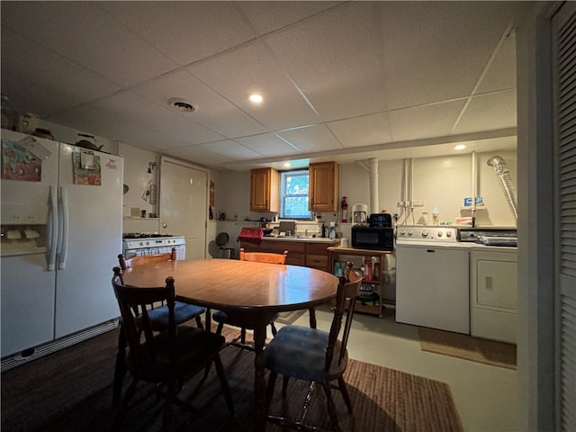 dining area featuring a drop ceiling and washer and dryer