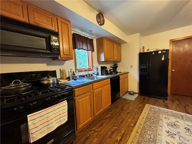 kitchen featuring black appliances, sink, and dark wood-type flooring