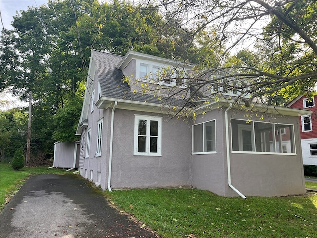 view of side of property featuring a sunroom and a yard