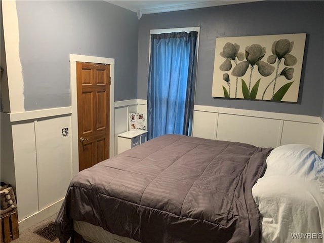 bedroom with crown molding and carpet