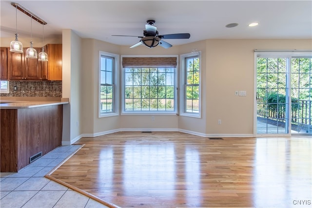 unfurnished living room with ceiling fan and light hardwood / wood-style floors