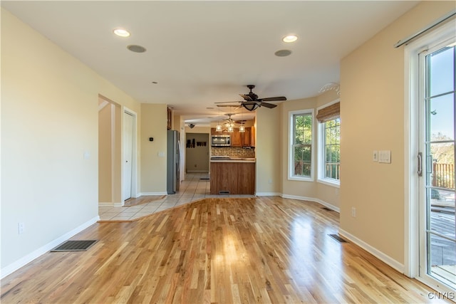 unfurnished living room with ceiling fan and light hardwood / wood-style floors