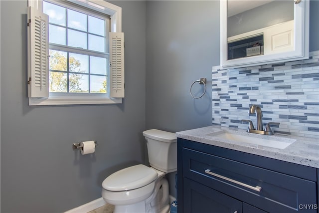 bathroom featuring vanity, decorative backsplash, and toilet