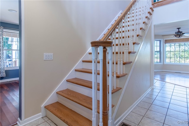 stairs featuring ceiling fan and tile patterned flooring