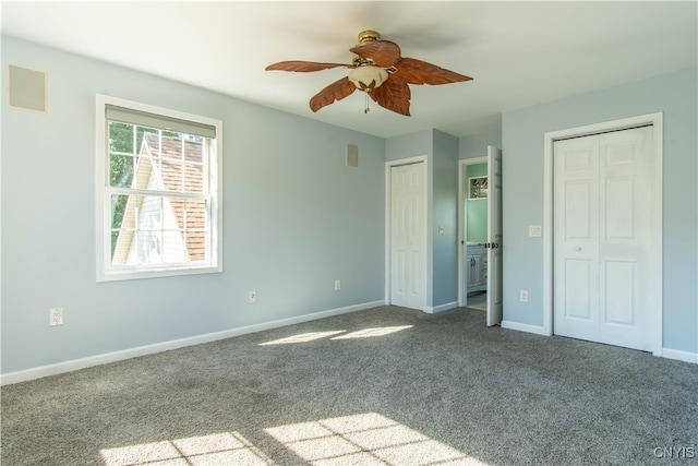 unfurnished bedroom featuring two closets, carpet flooring, and ceiling fan