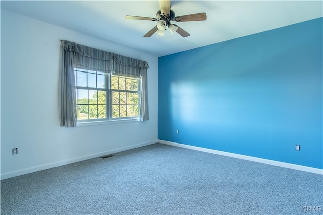 carpeted spare room featuring ceiling fan