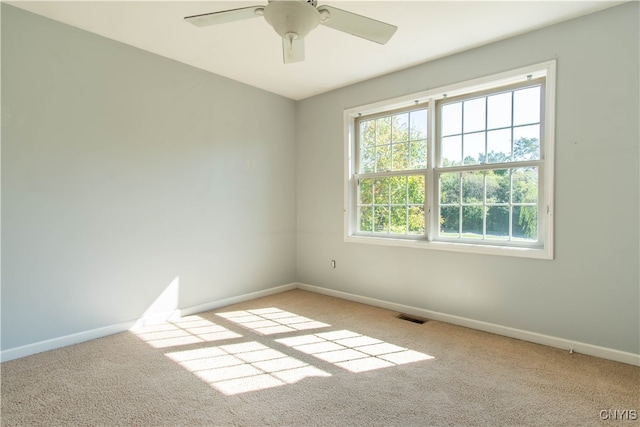 carpeted spare room with ceiling fan