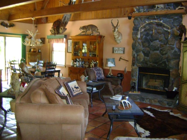 living room with tile patterned flooring, a stone fireplace, beamed ceiling, and plenty of natural light