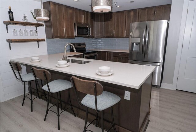 205 Lakeshore Dr Unit 520, Canandaigua City, NY 14424 - kitchen with stainless steel appliances, a sink, light countertops, a peninsula, and light wood finished floors