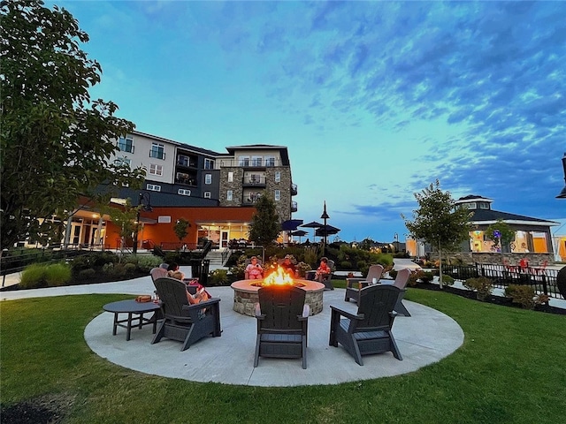 patio terrace at dusk with a gazebo, an outdoor fire pit, and a yard