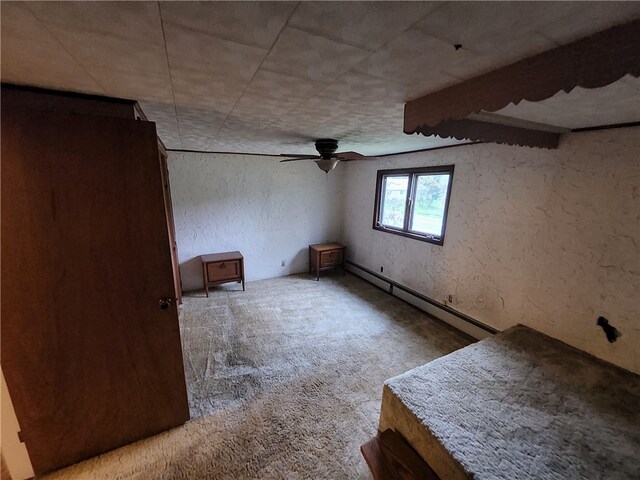 unfurnished bedroom with a baseboard heating unit, ceiling fan, and light colored carpet