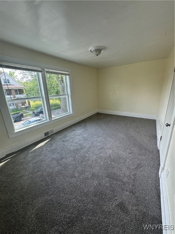 spare room with dark colored carpet