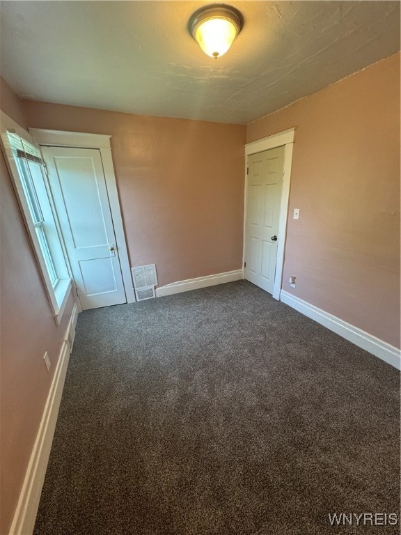 unfurnished bedroom featuring dark carpet