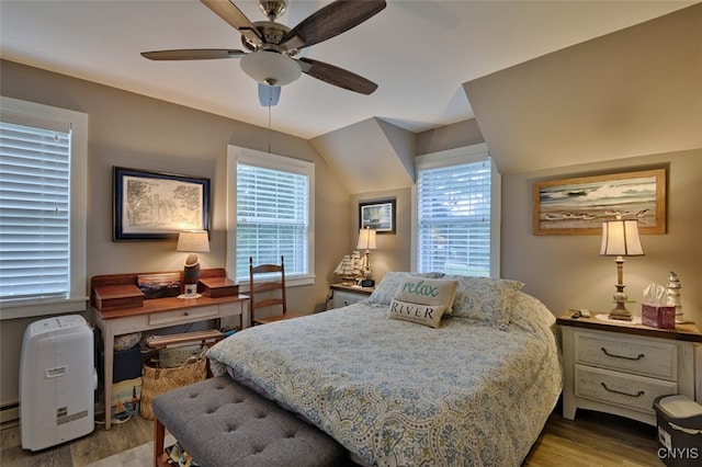 bedroom featuring multiple windows, lofted ceiling, ceiling fan, and light hardwood / wood-style flooring