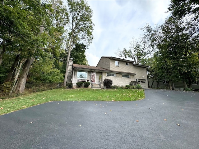 view of front of property featuring a garage and a front lawn