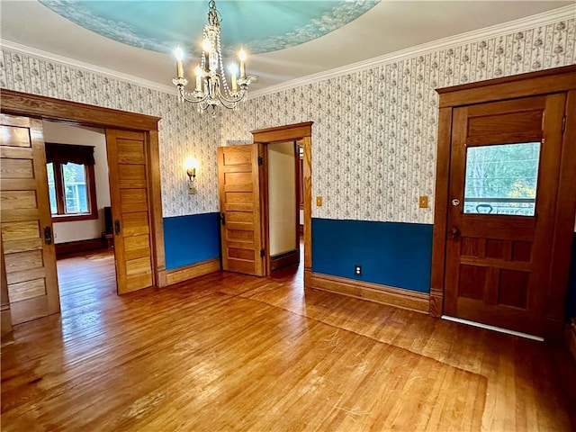 247 W Corydon St, Bradford-Town, PA 16701 - unfurnished dining area with baseboards, a chandelier, wallpapered walls, crown molding, and hardwood / wood-style flooring