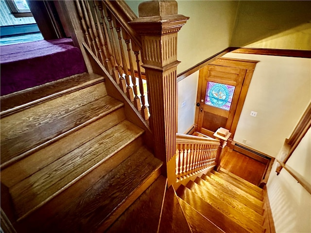 stairway with a baseboard radiator and hardwood / wood-style flooring