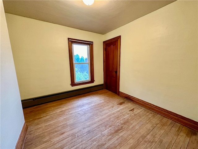 unfurnished room featuring light hardwood / wood-style flooring and a baseboard radiator