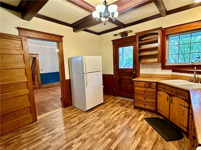 kitchen featuring sink, beam ceiling, a chandelier, light wood-type flooring, and white fridge