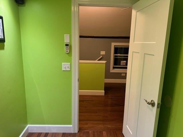 hallway with dark hardwood / wood-style flooring and crown molding