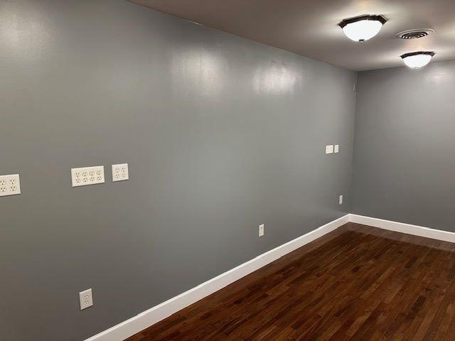 unfurnished room with hardwood / wood-style flooring