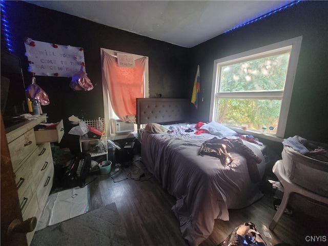 bedroom with cooling unit and hardwood / wood-style flooring