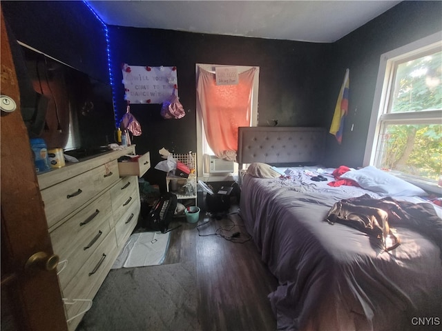 bedroom with cooling unit and dark hardwood / wood-style floors