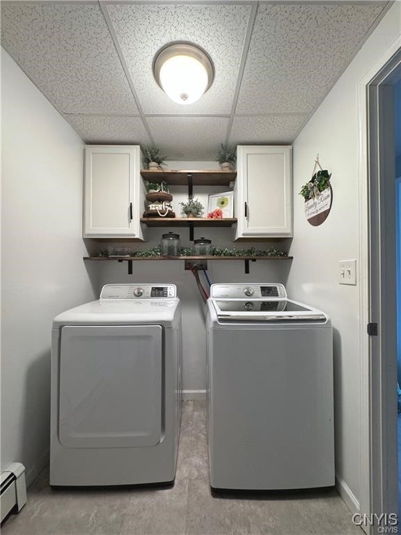 laundry room featuring cabinets, a baseboard heating unit, and separate washer and dryer