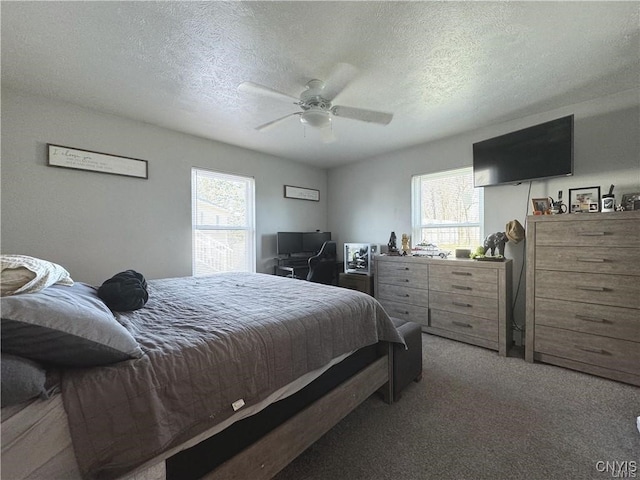 bedroom with a textured ceiling, carpet flooring, and ceiling fan