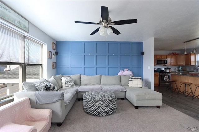 living room featuring wood-type flooring and ceiling fan