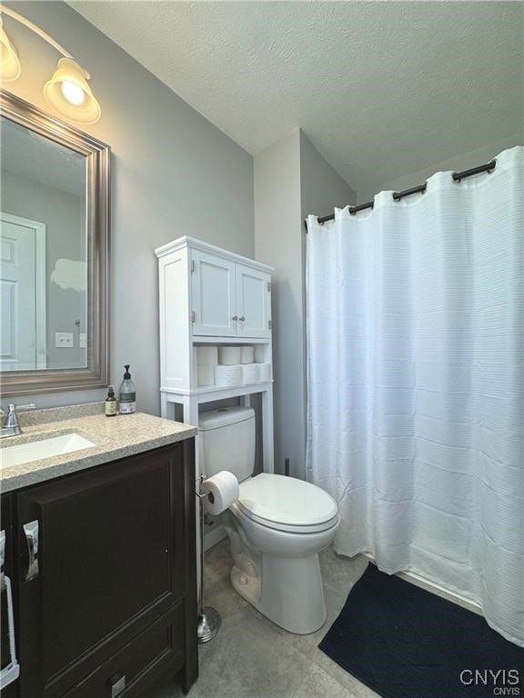 bathroom featuring vanity, a textured ceiling, toilet, and a shower with shower curtain