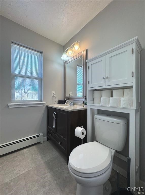 bathroom with a textured ceiling, vanity, toilet, and a baseboard radiator