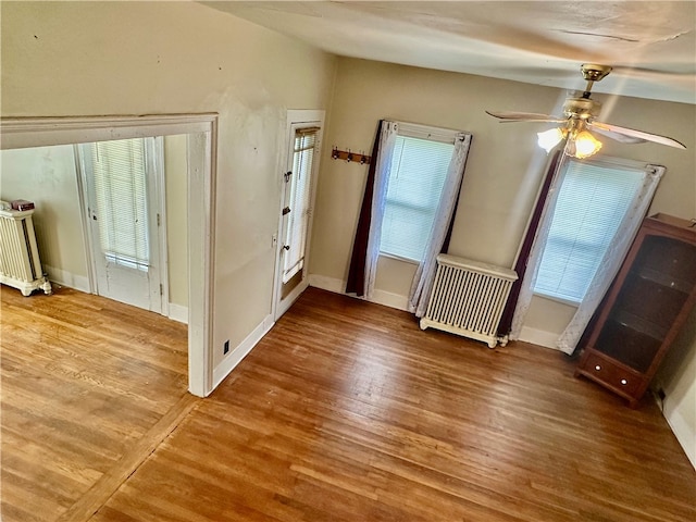 interior space featuring radiator heating unit, ceiling fan, and hardwood / wood-style floors