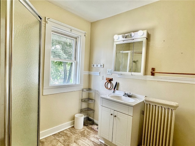 bathroom with tile patterned flooring, vanity, radiator, and a shower with door