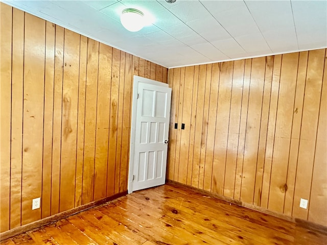 empty room featuring wooden walls and hardwood / wood-style flooring