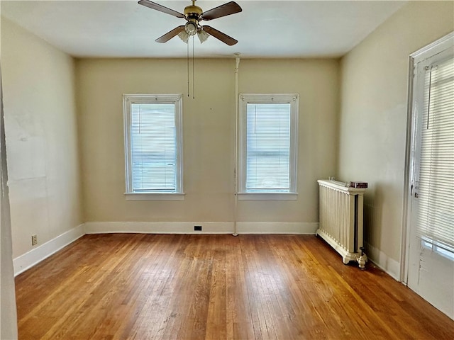 unfurnished room with radiator, plenty of natural light, and light hardwood / wood-style floors